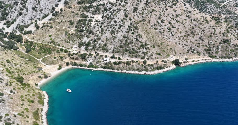 Beautiful aerial drone footage of a hidden beach on Hvar Island, Croatia, surrounded by crystal-clear turquoise water, rocky coastline and natural Mediterranean landscape. Scenic travel destination