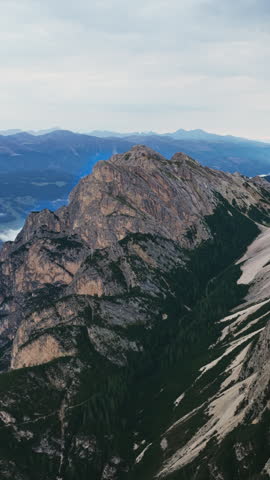 Massive Rock Mountains Rise On Lago di Braies (Pragser Wildsee) In The Dolomites Of South Tyrol In Northern Italy. Vertical, Aerial Shot