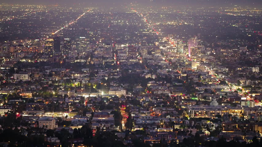 Thousands of city lights spread across Los Angeles after dark, creating an expansive urban panorama filled with illuminated neighborhoods, distant skyscrapers and vibrant California nightlife.