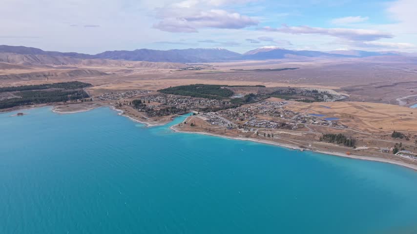 Aerial view of Lake Tekapo township beside turquoise lake and open landscape