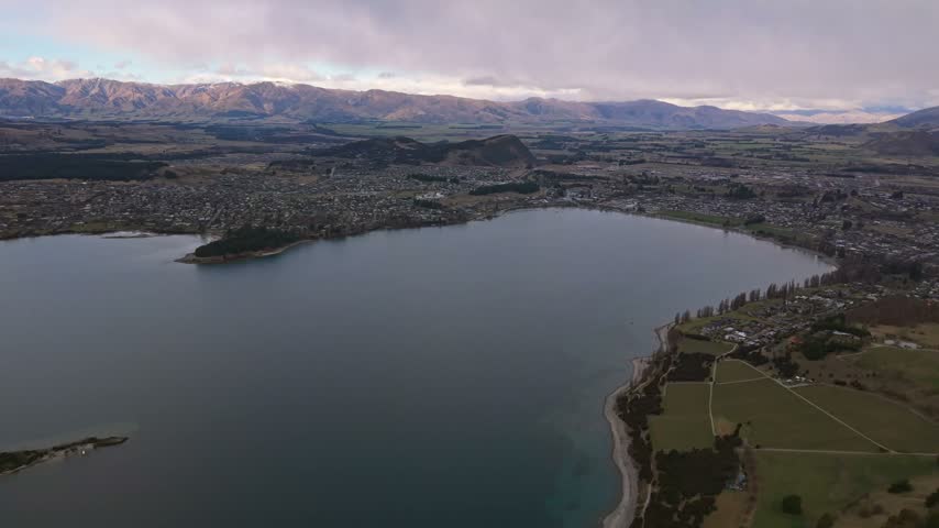 Aerial view of Lake Wanaka, Ruby Island, and Wanaka township with distant mountains