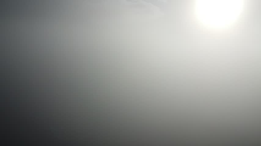 Aerial shot of a flight upwards through the fog over a river at dawn.