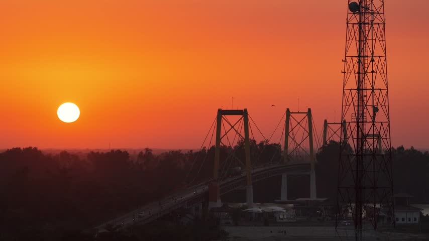 Sunset over a bridge and tower in Banjarmasin, Indonesia.