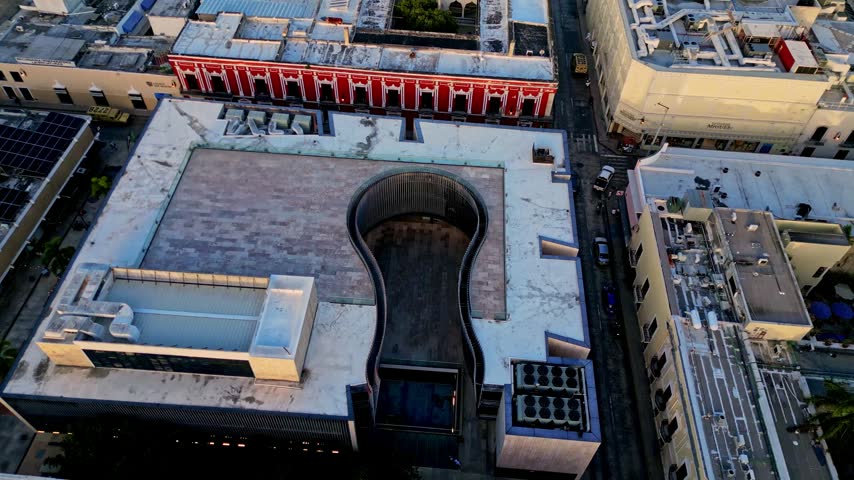 Stunning aerial top down view slowly descending over the Palacio de la Musica Mexicana, revealing its unique keyhole shaped architecture in the historic city center of Merida, Yucatan
