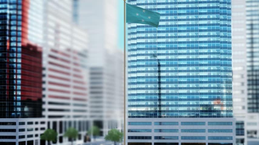 Federated States of Micronesia Flag Waving by Modern Glass Buildings - Daytime