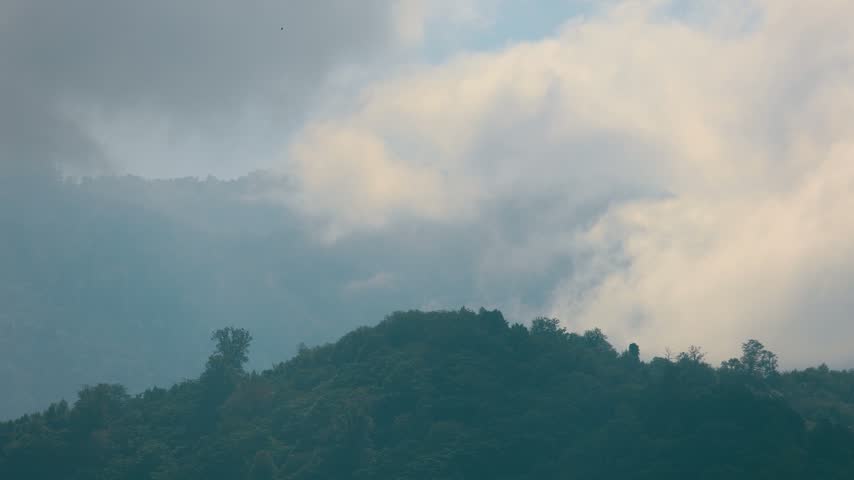 Dramatic Clouds Over Forested Hills at Sunset
