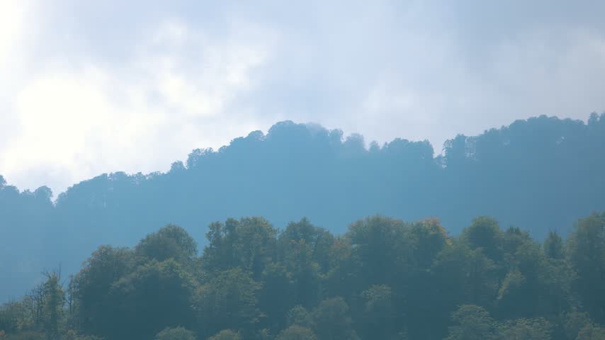 Dramatic Clouds Over Forested Hills at Sunset