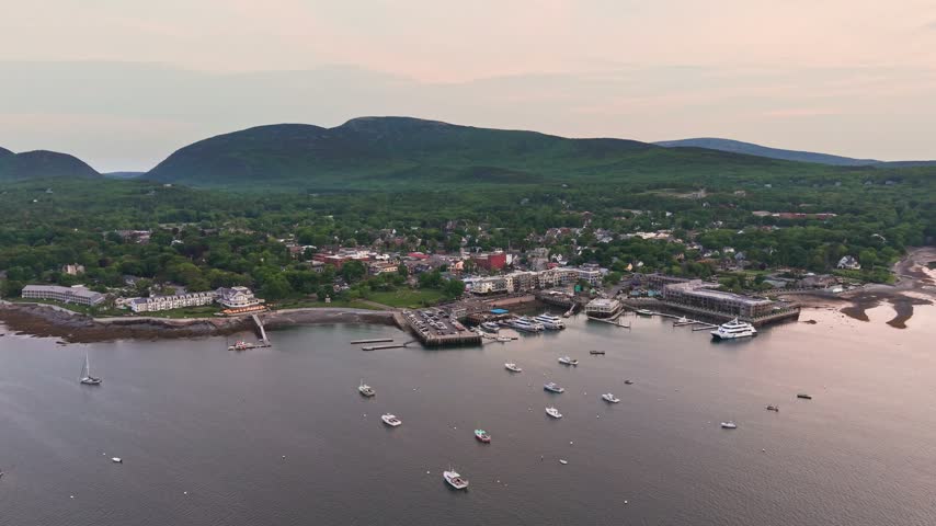 Aerial view of Bar Harbor town and Frenchman Bay with the mountains of Acadia National Park at dusk, Maine, USA.