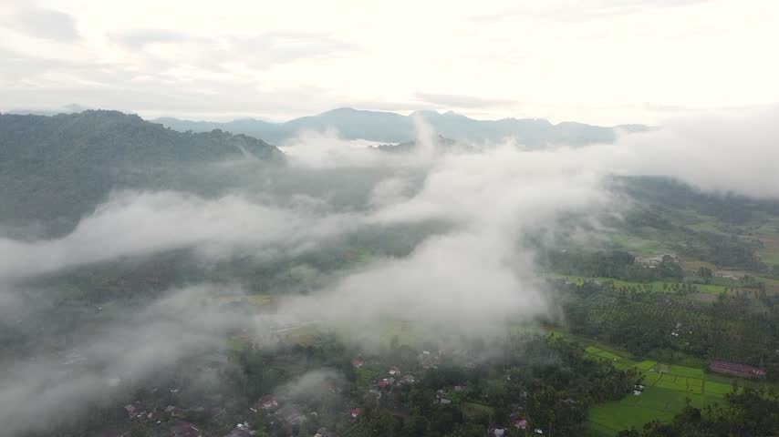 Aerial view of misty village valley covered in clouds