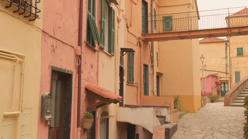Pastel facades line a stone lane in Porto Maurizio old town, Imperia on the Italian Riviera