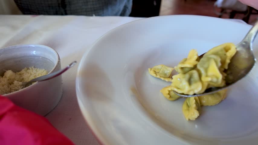 Close-up of fresh Italian stuffed agnolotti pasta served on a plate at a restaurant table.