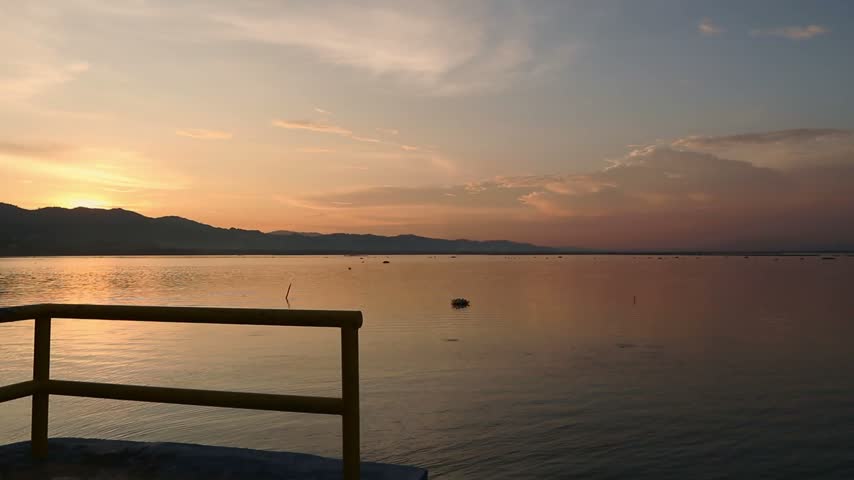 Silhouette of Person Watching Sunset Over Lake