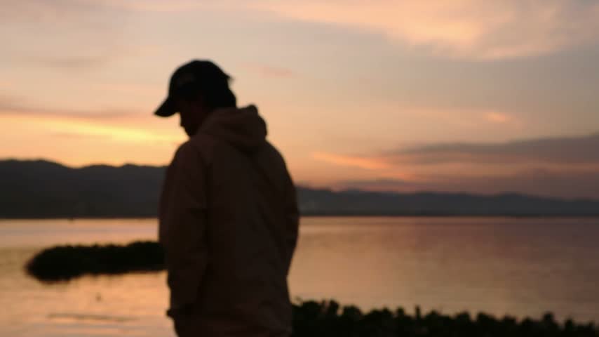 Silhouette of Person Watching Sunset by Lake