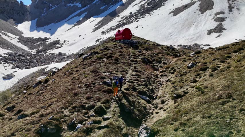 Hikers walking along a steep rocky mountain trail surrounded by dramatic cliffs and clounds. Majestic Dolomite Mountains.