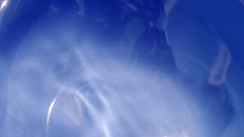 Slow-motion shot of a water droplet falling onto the water