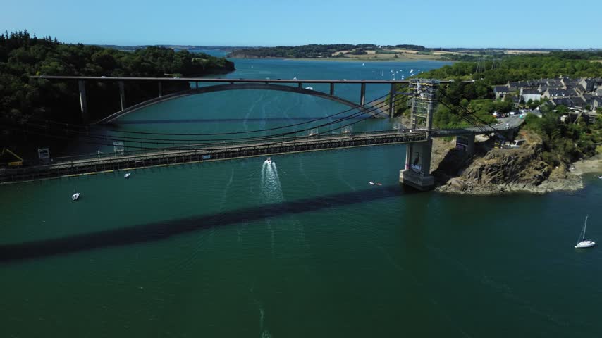 Aerial drone view of Pont Saint-Hubert crossing the Rance River in Brittany, France, with the surrounding green landscape and deep blue-green water visible from above.