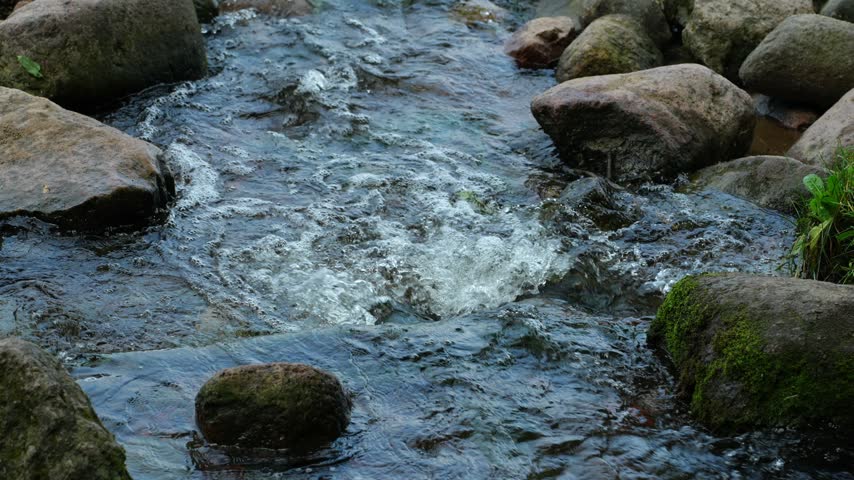 Small waterfall in a stream between stones