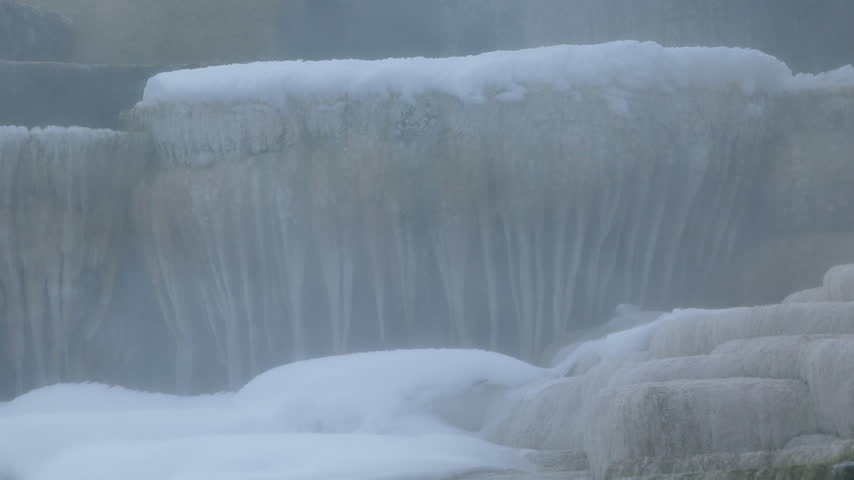A Shot of Very Large Icicle Stalactites with Steam Blowing Across at Hot Springs in Yellowstone National Park in Winter