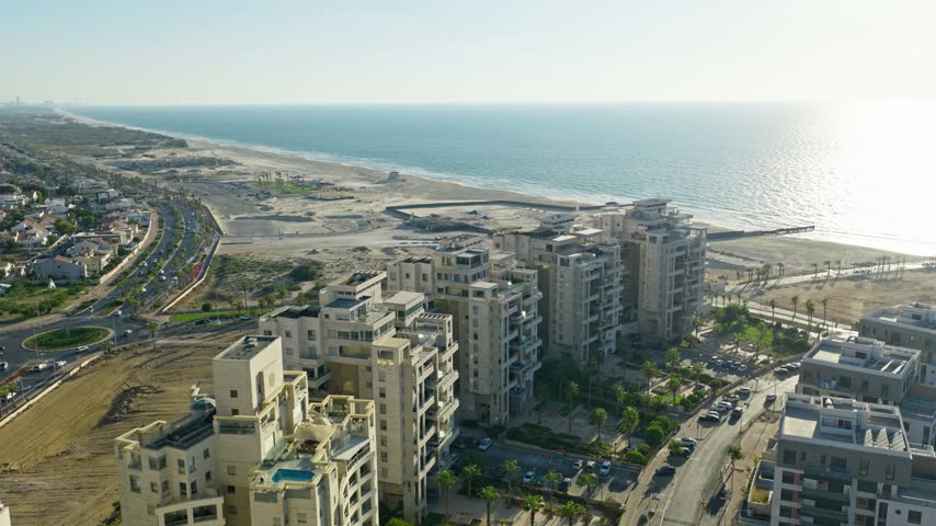 Aerial drone shot of luxury residential buildings and penthouses located in Ashdod Israel with the Mediterranean Sea and coastline in the background.