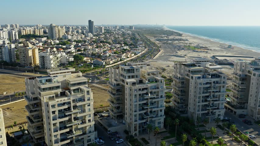 Aerial drone shot of luxury residential buildings and penthouses located in Ashdod Israel with the Mediterranean Sea and coastline in the background.