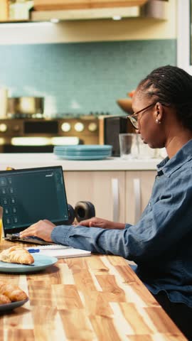Portrait format: Young adult interacting with AI image generator chatbot through interface on laptop, artificial intelligence and text-to-image software