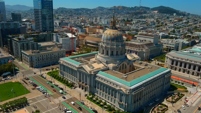Aerial drone footage showcasing the Idaho State Capitol Building surrounded by downtown Boise, Idaho, with city streets, modern buildings, and scenic hills in the background. Ideal for travel, tourism, government, urban development, cityscape, and architectural projects.
