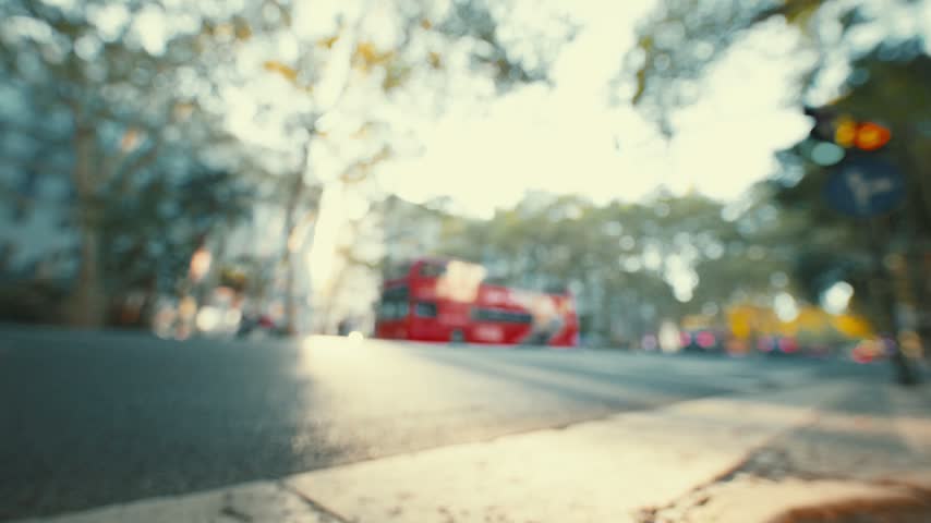 Red double-decker bus moves along the street in a busy city area