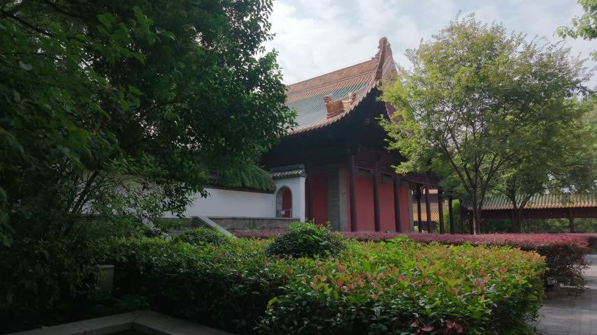 Nanjing, China - September 25th 2026 - Photo of facade of a traditional Chinese hall with red timber walls, grey tiled roof and whitewashed courtyard walls.