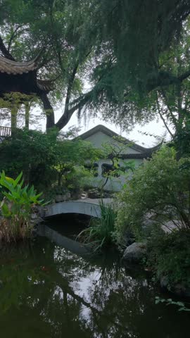 Nanjing, China - September 25th 2026 - Photo of close view of a traditional Chinese pavilion above a garden pond with ornamental fish and stone terrace.