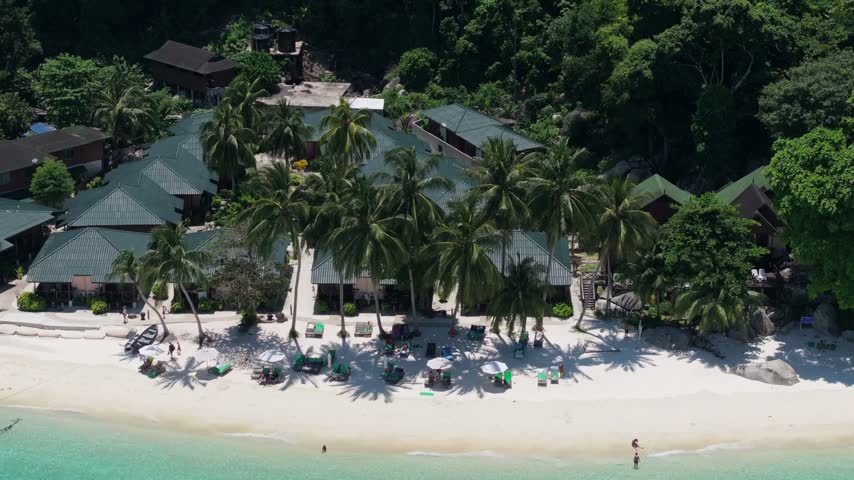 Aerial view of Perhentian Islands resort with tropical palm trees, white sand beach, and turquoise water in Terengganu, Malaysia.