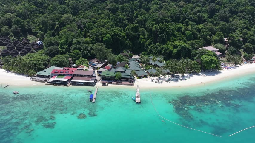 Aerial view of Perhentian Islands resort with white sand beach, turquoise water, and lush jungle in Terengganu, Malaysia.