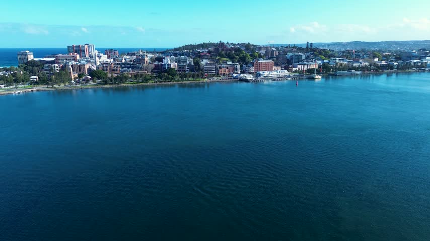 Drone aerial landscape of Newcastle city harbour with residential urban apartment buildings and commercial shops along Honeysuckle waterfront foreshore next to the Hunter River in Australia tourism