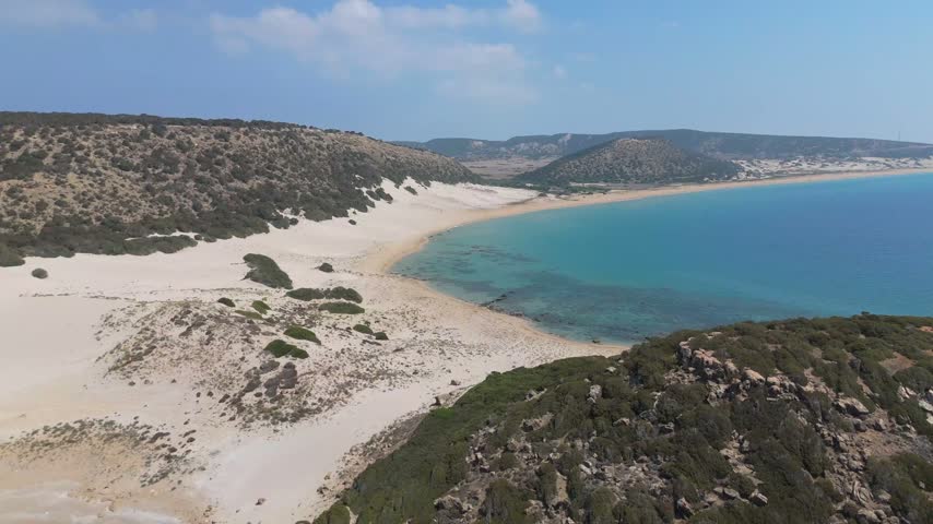 Aerial view of the pristine sandy beach and turquoise waters along the rugged coastline of Famagusta, Famagusta, Northern Cyprus.