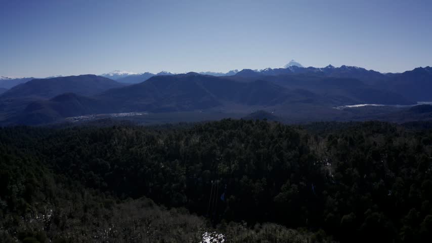 Aerial view of snowy mountains and forest in southern Chile