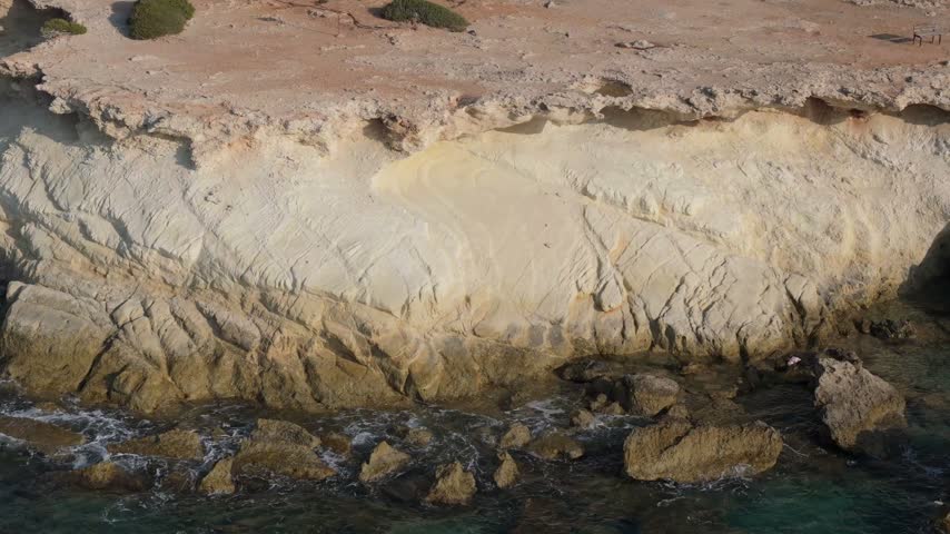 Aerial view of coastal cliffs and rocky shoreline along the Mediterranean Sea in Nicosia, Nicosia, Cyprus.