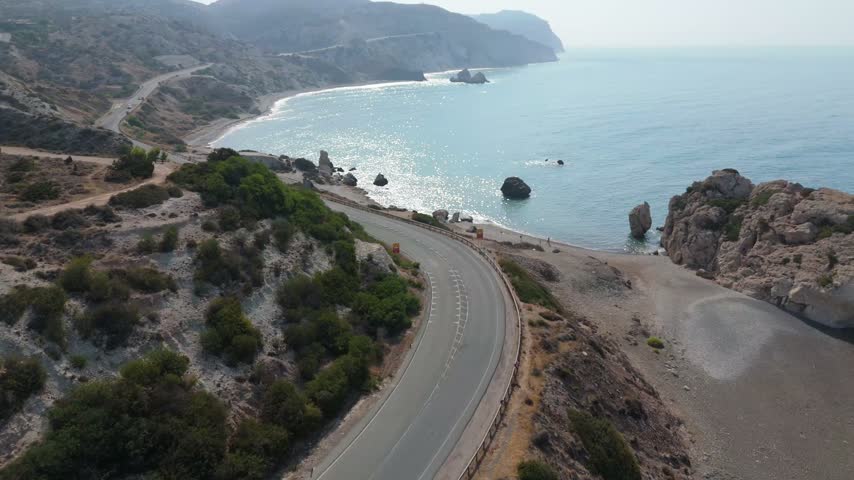 Aerial view of a car driving along the winding coastal road near Aphrodite