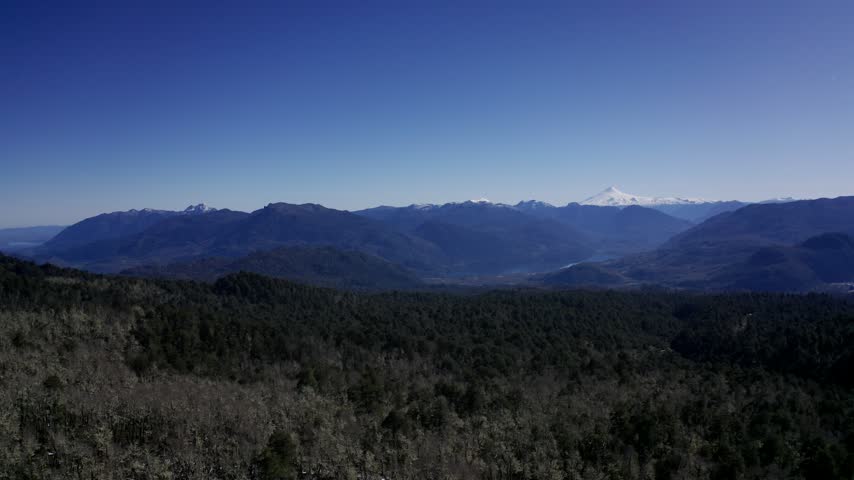 Aerial view of snowy mountains and forest in southern Chile