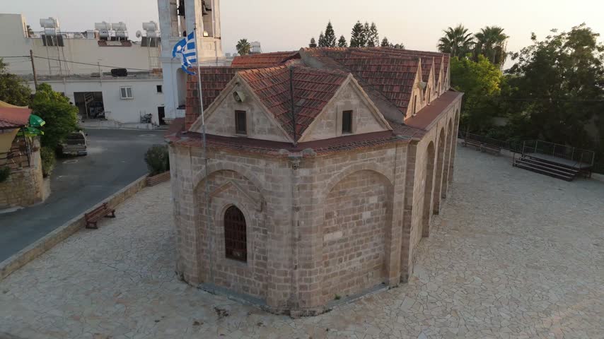 Aerial view of stone church with red tile roof and Greek flag in Nicosia, Nicosia, Cyprus.