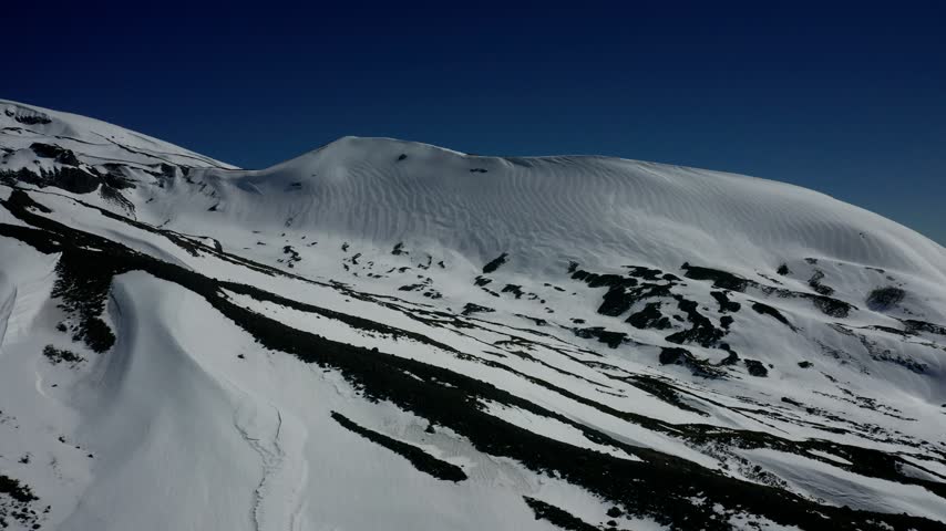 Aerial view of snowy mountains and forest in southern Chile