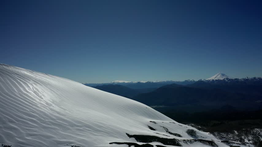 Aerial view of snowy mountains and forest in southern Chile