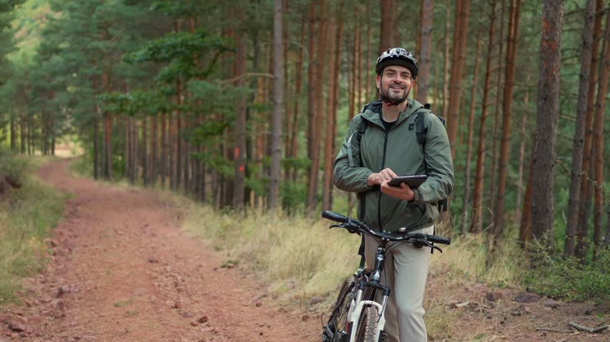 Cycling through the woods while checking a device for trail navigation