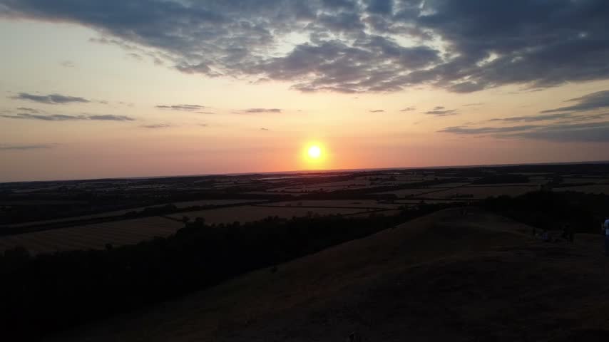 Aerial footage showing the rolling landscape around Burton Dassett Hill, Warwickshire, during a peaceful sunset evening.