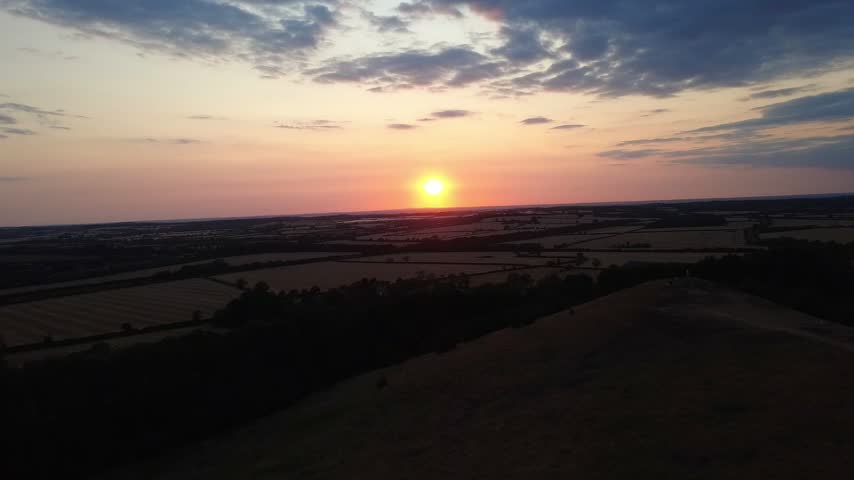 Aerial footage of the Warwickshire countryside surrounding Burton Dassett Hill, featuring open farmland, rolling hills and warm sunset light.