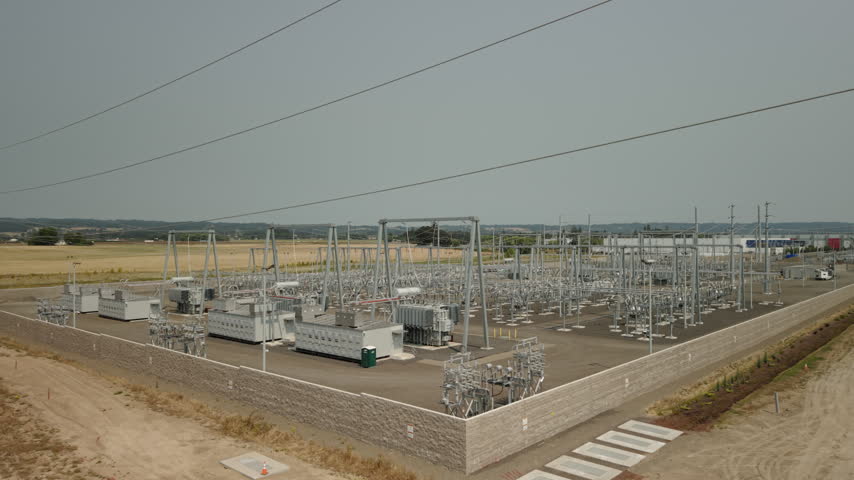 Aerial view of an electrical substation in Hillsboro, Oregon, showing transformers, transmission lines, and switching equipment near a major data center complex.