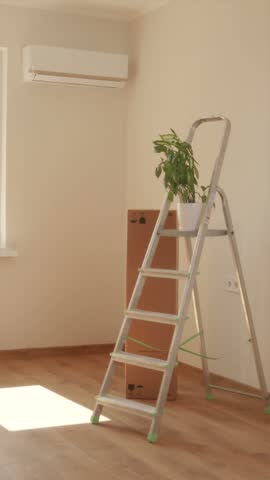 Happy man raising hands and celebrating moving into new bright spacious apartment room.