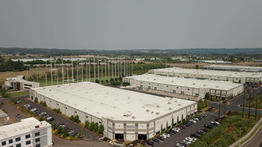 View of large data center complexes in Hillsboro, Oregon, featuring industrial buildings and rooftop cooling systems supporting cloud computing, AI, and digital infrastructure. Slow drone orbit