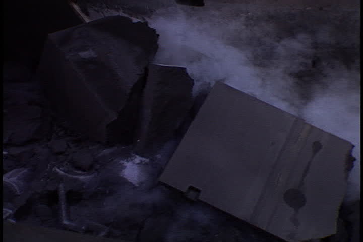 Broken sand molds and steel castings carried down conveyor and into blue pipe in St. Cloud, Minnesota.