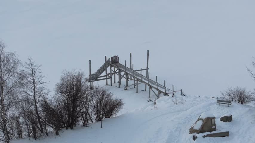 Aerial view of a wooden staircase structure set in a snowy landscape in Graun im Vinschgau, Trentino-Alto Adige S, Italy.