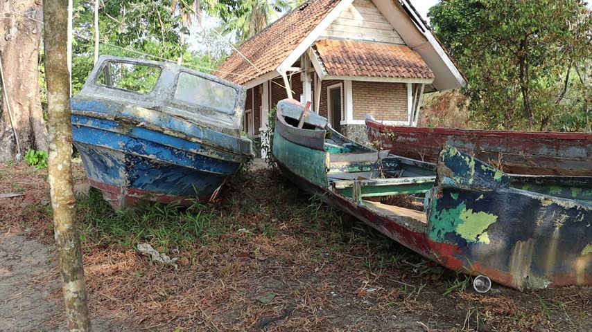 Abandoned Old Speedboat with Peeling Paint Resting on Ground