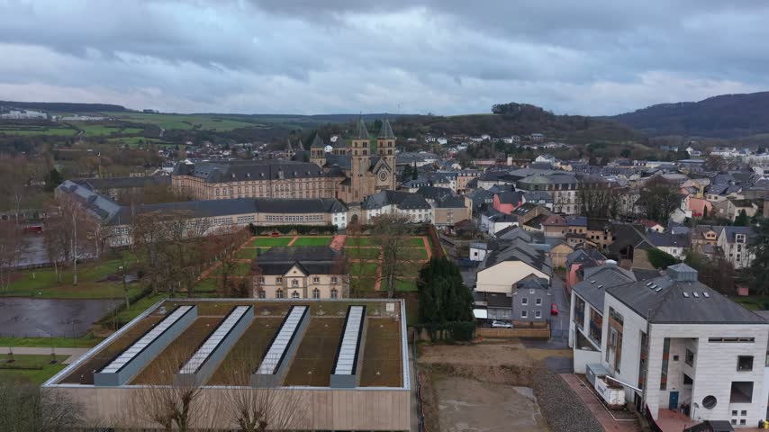 Aerial view of the historic Abbey of Echternach surrounded by town rooftops and green gardens in Echternach, Echternach, Luxembourg.